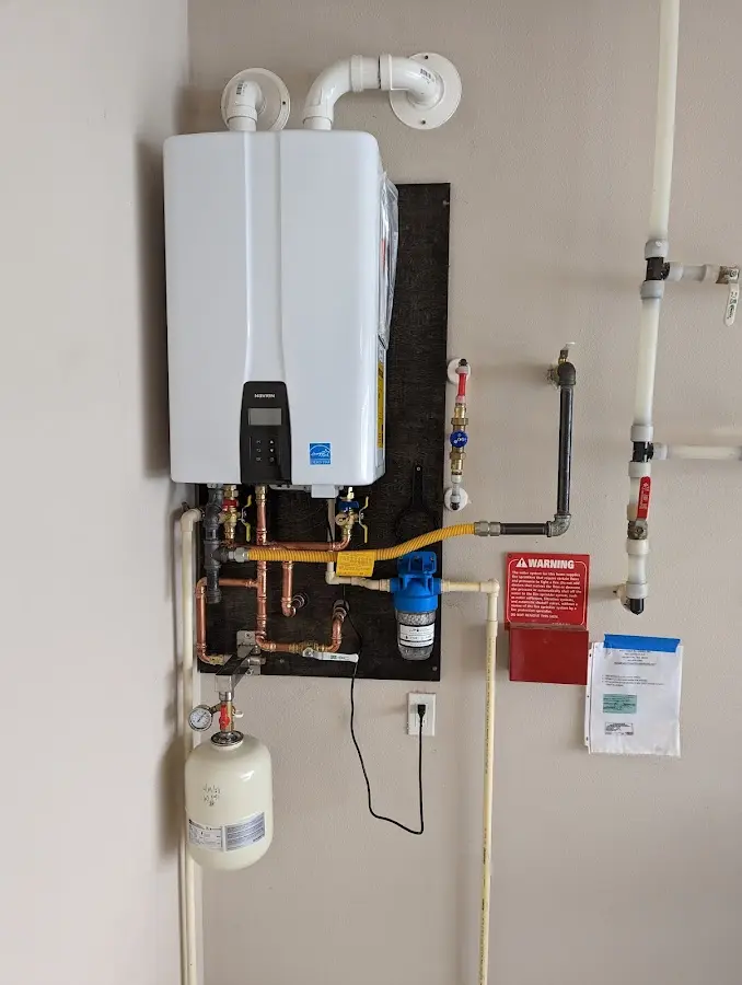 Professional plumber installing copper piping in a Mill Creek East home